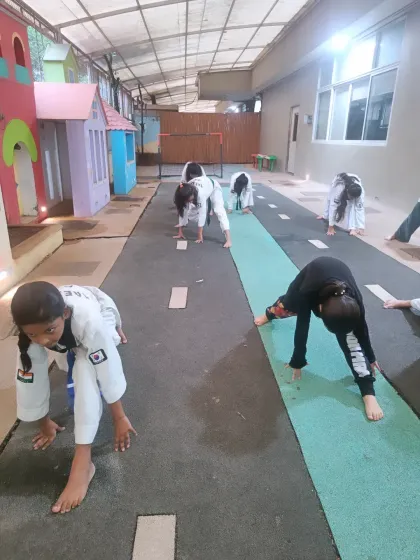 A wide view of our students engaged in stretching exercises. We dedicate a significant portion of each class to flexibility to ensure our students' bodies are prepared for dynamic movements.