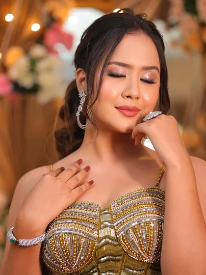 A moment of serene beauty. The soft, glowing makeup and the elegant ponytail create a look that is both modern and timeless for a reception.