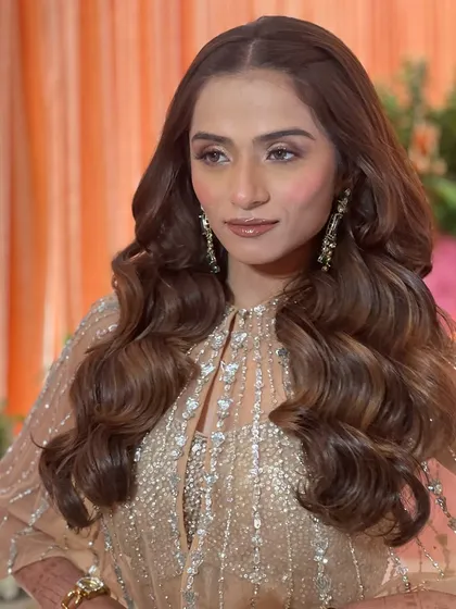 The bride's reception look is pure glamour, with her hair styled in classic, elegant waves that frame her face perfectly.