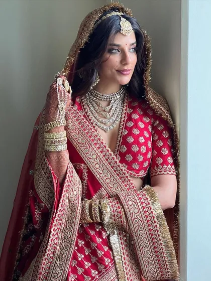A classic bridal look will always have my heart. Here, the beautiful Carla Dennis is a vision in a traditional red Sabyasachi lehenga, paired with an incredible multi-layered polki necklace. This look is all about timeless elegance and regal grace.