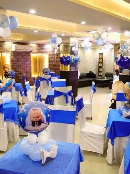 The dining area of a Boss Baby themed party, with themed centerpieces and chair covers.