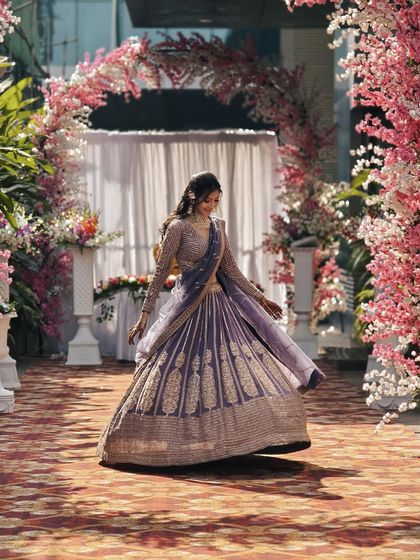 A beautiful motion shot of the mauve-purple lehenga, showing off its graceful drape and detailed work.