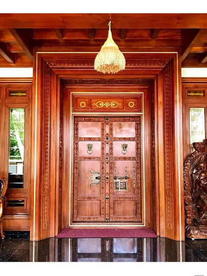 This intricately carved main door is a testament to our deep appreciation for traditional Kerala craftsmanship. We collaborate closely with master artisans to create authentic, detailed woodwork that becomes the soul of a home.