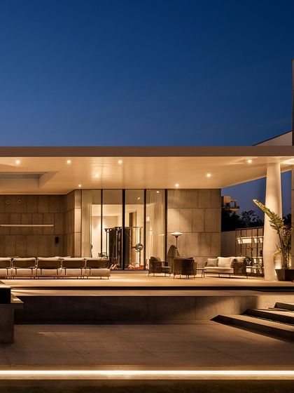 The back elevation of the Ananda residence is designed to feel like a peaceful retreat. A covered patio with comfortable seating overlooks the pool, offering a space to unwind. The design blends modern louvers with Southeast Asian influences for a calm, resort-like atmosphere.