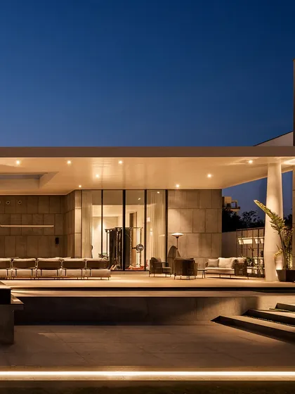 The back elevation of the Ananda residence is designed to feel like a peaceful retreat. A covered patio with comfortable seating overlooks the pool, offering a space to unwind. The design blends modern louvers with Southeast Asian influences for a calm, resort-like atmosphere.