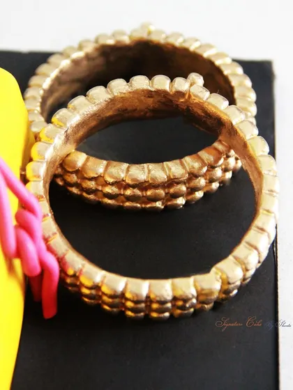 The edible gold bangles from the Saree Cake, meticulously crafted to look like real jewelry.