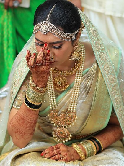 A bride during her wedding ceremony, her hands adorned with a beautiful, dark mehendi stain.