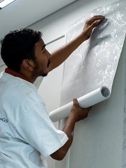 The final steps of a wallpaper installation. Our team's expertise ensures that every seam is perfect and the pattern aligns seamlessly, bringing the design to life on your walls.