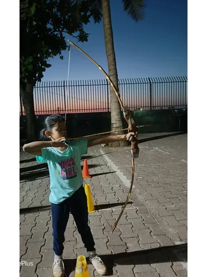 A young girl takes aim, showing the determination of our students.