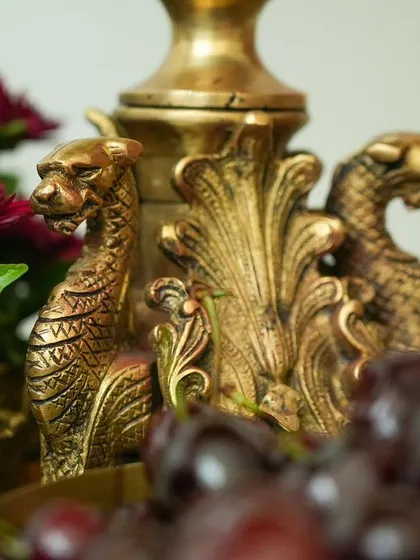 A macro shot of an antique brass prop featuring mythical creatures. Sourcing unique, detailed props like this is a skill I teach to elevate your designs from standard to extraordinary.