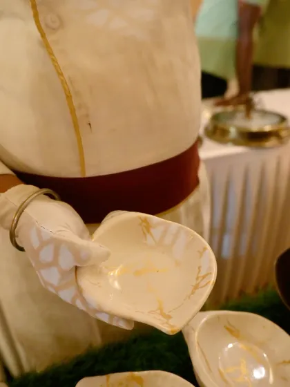 A chef presents a finished appetizer bowl, showcasing the elegant serveware we use. The focus is on providing a complete, high-quality dining experience.