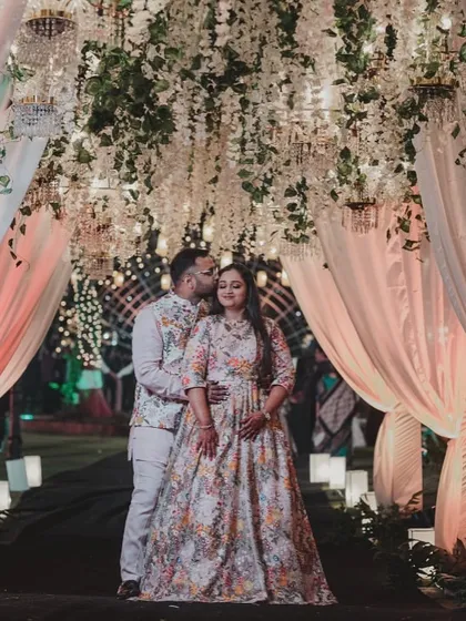 A romantic portrait of the couple under a canopy of hanging white flowers and soft drapes. This setup provided a beautiful, soft-focus backdrop for their photos.