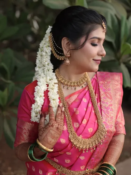 A side profile highlighting the intricate temple jewellery and the soft, glowing makeup.