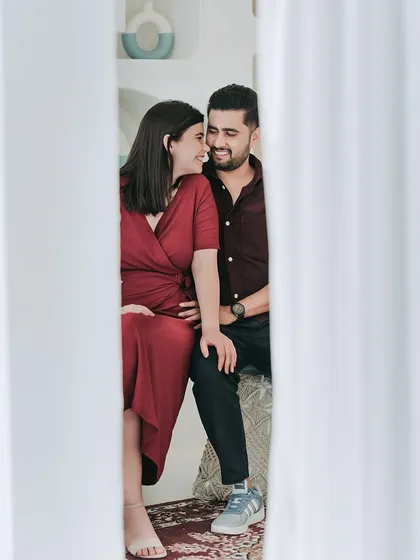 A creative shot peeking through white curtains, capturing an intimate and private moment between the couple.