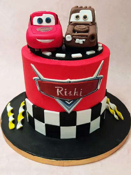 Get ready to race with our two-tier Cars movie cake, featuring Lightning McQueen and Mater on a track, with a checkered flag base.