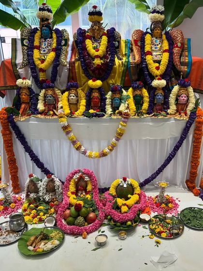 A beautifully decorated pooja space during a housewarming ceremony. The idols are adorned with flowers and offerings, filling the home with divine blessings.