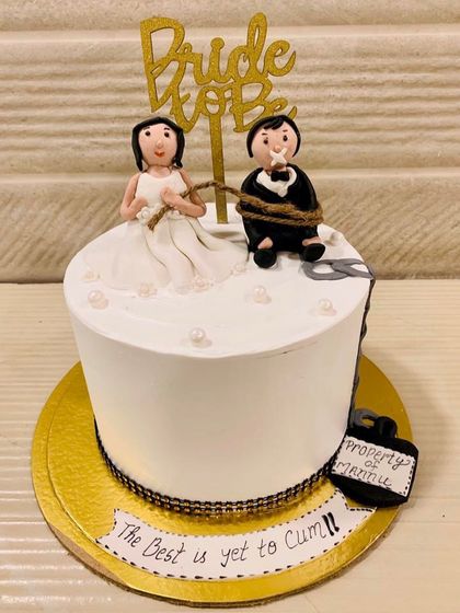 A funny and cheeky "Bride to Be" cake, featuring a fondant bride tying up her groom. Perfect for a bachelorette party with a sense of humor.