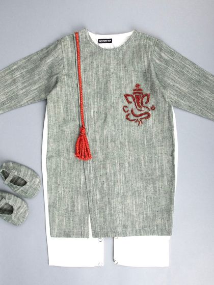 A flat-lay of a kids' ethnic kurta set, featuring a grey Ganesha-embroidered kurta, white pants, and matching shoes.
