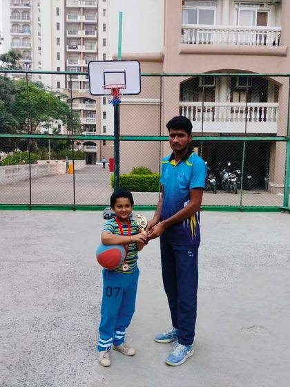 A young athlete proudly holds his trophy after being recognized for his performance at a Ranking Day. These moments build confidence and motivation.