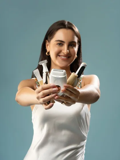 Showcasing a collection of grooming tools. The model presents the products to the camera, giving a clear view of each item. This style of shot is effective for demonstrating product variety and use.