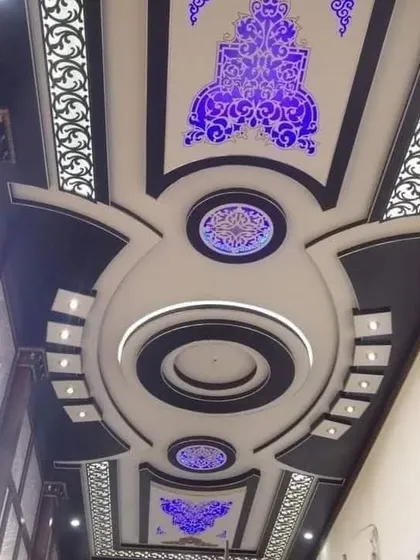 A majestic ceiling for a long hall, featuring ornate backlit jali panels in a deep purple. The symmetrical design creates a sense of formality and grandeur.