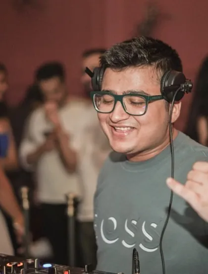 Spreading good vibes from the DJ booth. A simple shaka sign to connect with the crowd.