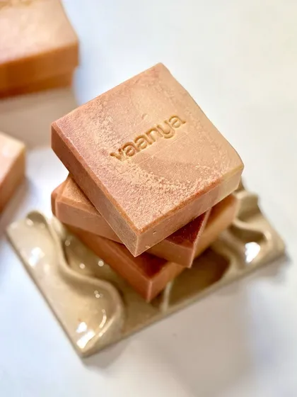 A stack of our custom Plumeria soaps on a beautiful ceramic soap dish by Jellyfish Pottery.