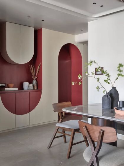 A view connecting the dining area to the custom passage storage unit. The repetition of the arch motif and the bold red color creates a strong visual link between the two zones.