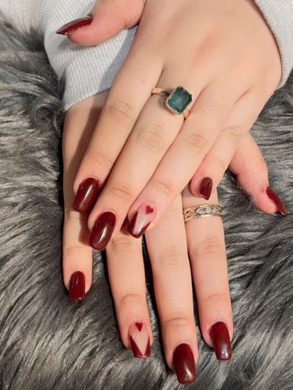A deep maroon set with a 'negative space' heart design on the accent nails, perfect for a subtle, romantic statement.