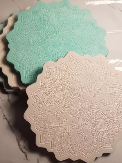 A stack of our Mandala coasters in pastel blue, green, and white, ready to be used or gifted.