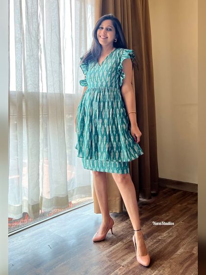 This sea-green Ikat dress features delicate ruffles on the sleeves. It’s a short, fun, and flirty design that’s perfect for a party or a special day out.