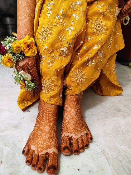 A full view of the bridal feet mehendi for Tahani. The design is detailed from her toes all the way up to her ankles.