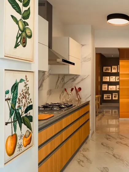 The kitchen is the true heart of the home. We designed this space with clean lines, a marble backsplash, and warm wood cabinetry to be both highly functional and beautifully integrated with the living areas. The botanical art adds a touch of nature, reinforcing our biophilic design approach.