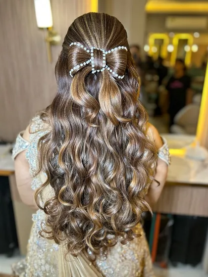 A beautiful engagement hairstyle with a pearl bow accessory. This is a trendy and cute way to style long hair for a special occasion.