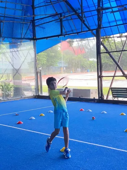 A young player perfects his forehand on our covered court. The bright blue surface and excellent lighting provide a professional training environment, protected from the elements.