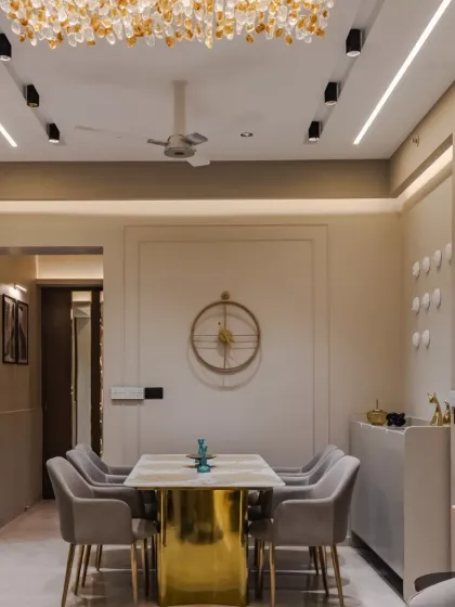This site embodies modern opulence and functional elegance, blending a neutral palette with gold accents, rich textures, and layered lighting to create an inviting ambiance. The seamless integration of the living and dining areas is complemented by plush furnishings and sculptural decor.