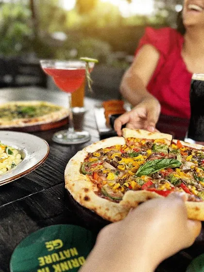 A slice of pizza, a sip of beer, and a whole lot of laughter. This is the kind of moment I love to see at my tables.