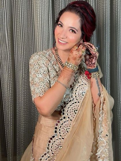 A candid shot of her putting on her earrings. This natural moment perfectly captures the soft and effortless feel of her party makeup.