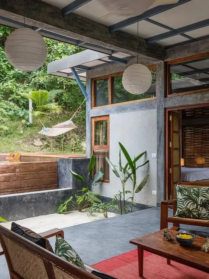 The living area of the private villa, complete with a hammock for ultimate relaxation. The design prioritizes comfort and a deep connection to the tranquil, natural surroundings.