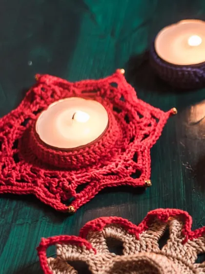 A star-shaped red crochet diya holder, perfect for adding a geometric touch to your decor. The gold bead accents on each point add a subtle sparkle.