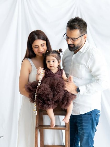 A sweet family portrait with their daughter playing with a string of pearls. It's the little, unexpected moments that often make the best photos.