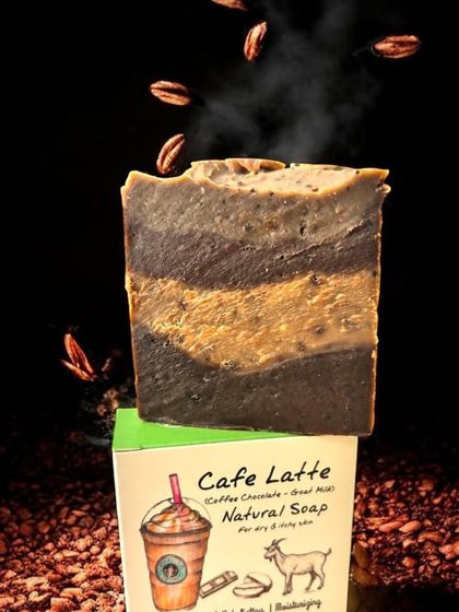 A dramatic shot of our Café Latte soap, with coffee beans appearing to fall around it. This highlights the key ingredient and the energizing nature of the soap.