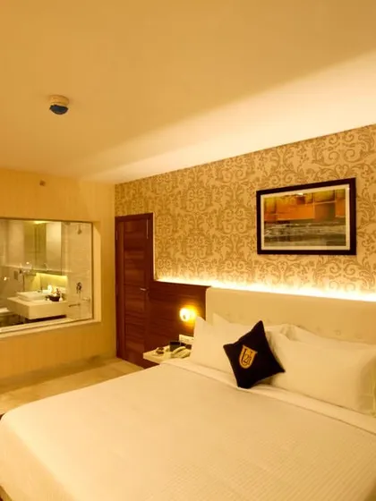 We also design for the hospitality sector. This is a hotel room we designed, featuring a modern and comfortable aesthetic with a glass partition to the bathroom.