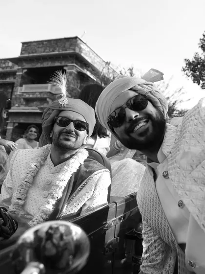 A fun black and white selfie of the groom and a friend during the baraat, capturing the excitement from their perspective.