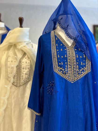 A closer look at the contrast between a sheer blue dupatta and an ivory kurta, both featuring delicate, handcrafted details.