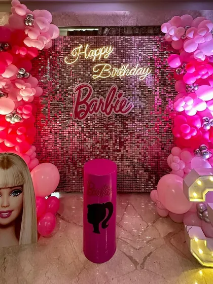 A dazzling Barbie theme birthday party perfect for a little fashionista. The decor is built around a pink sequin wall, with pink balloon columns, a "Happy Birthday Barbie" neon sign, and a large light-up number '3'.