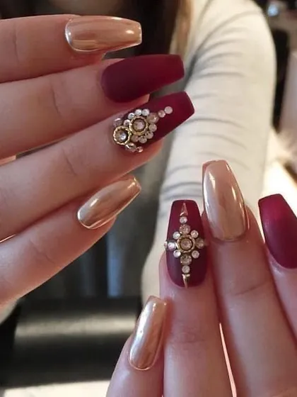This is an example of high-end bridal nail art, combining matte maroon polish, metallic gold chrome, and intricate 3D stone embellishments. My course includes a dedicated module on creating these luxurious, detailed designs for special occasions.