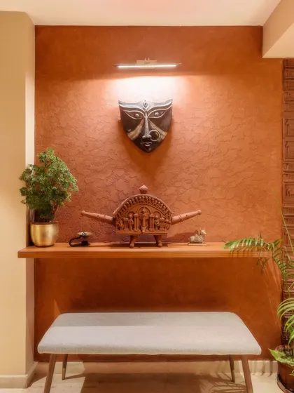 A close-up of the terracotta wall from image 4, showing the Durga mask and other artifacts.