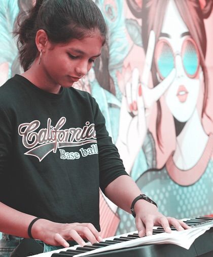 Our young keyboardist focused and in her element during a live performance at The Walk. We provide opportunities for students to shine on a real stage.