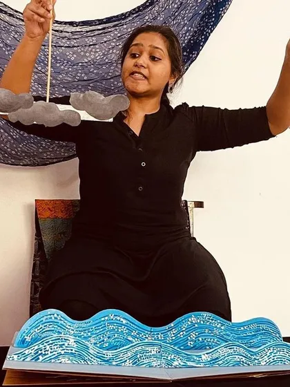 We use many forms of puppetry, including these simple but effective paper cutouts to create a scene with clouds and waves.